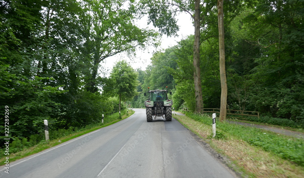 Fototapeta premium Tractor from behind, on a lonely country road