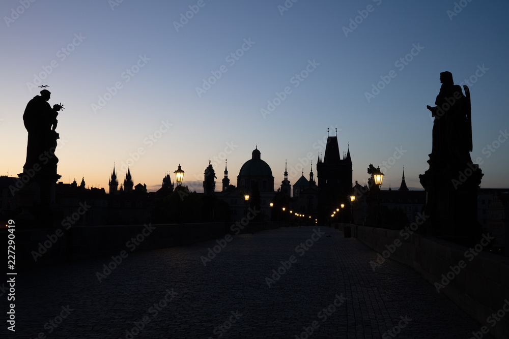 Blick am frühen Morgen über die Statuen der menschenleeren Karlsbrücke in Prag Richtung Altstädter Brückenturm