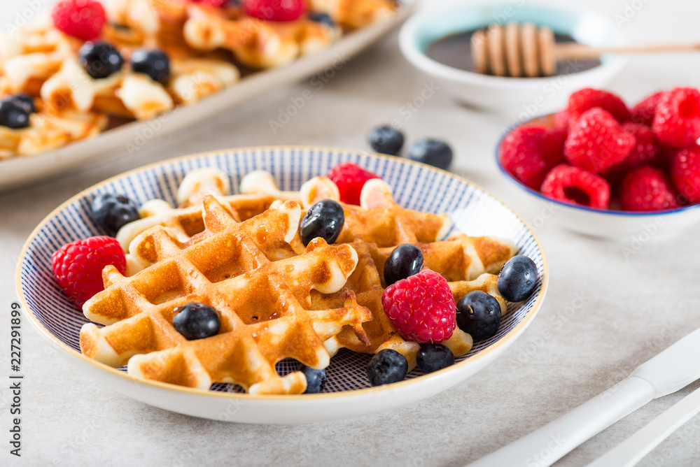 Traditional homemade belgian waffles with fresh berries and syrup Traditional homemade belgian waffles with fresh berries and syrup
