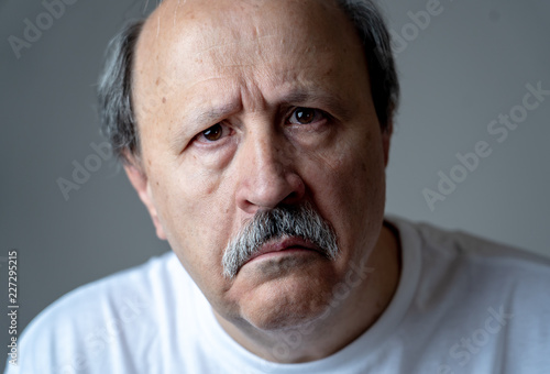 Close up portrait of sad old man face suffering from depression