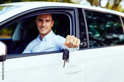 Car keys in the hand of a young man sitting in his car