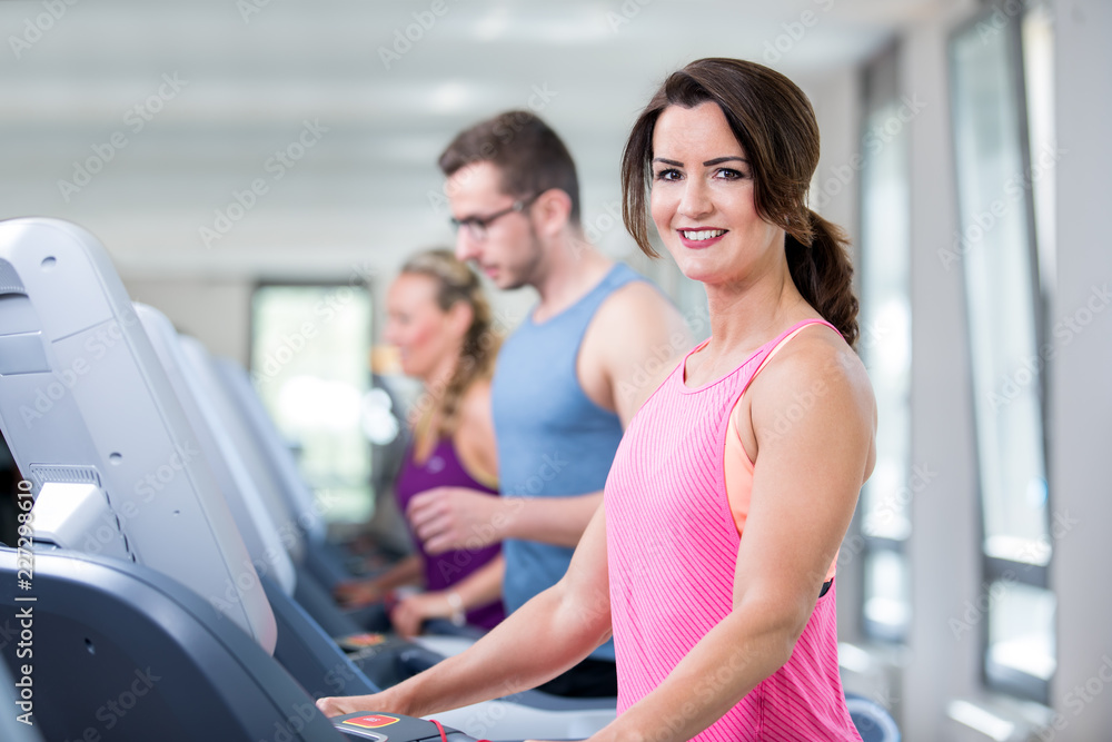 young beautiful woman are doing her sport running workout in the gym on a treadmill