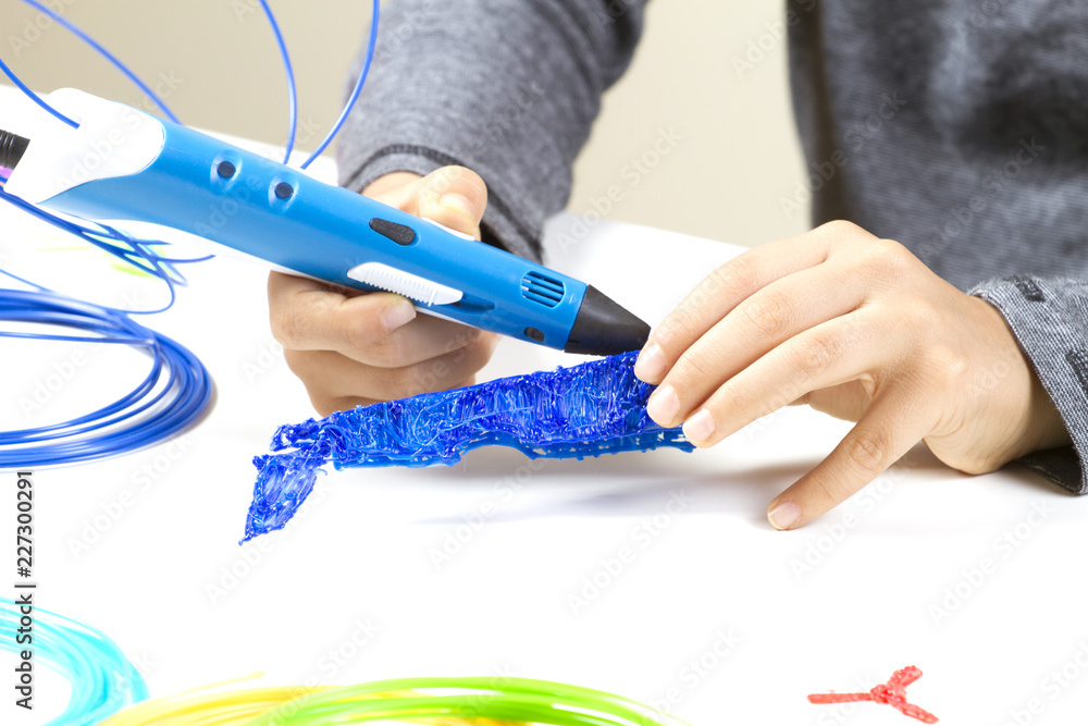 Kid's hands creating with 3d printing pen. Kid's hands creating with 3d printing pen.