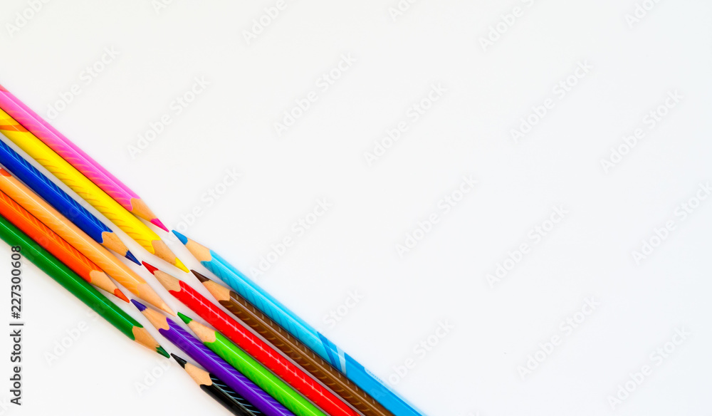 Colourful pencils on white paper background. Copy space for text