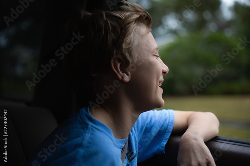 Portrait of a boy riding in a car with the window open.