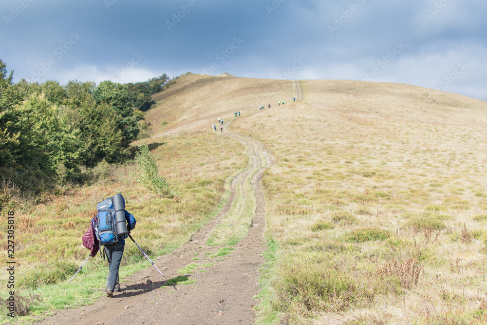 Woman with a large backpack with walking sticks in a hike in the mountains. Woman with a large backpack with walking sticks in a hike in the mountains.