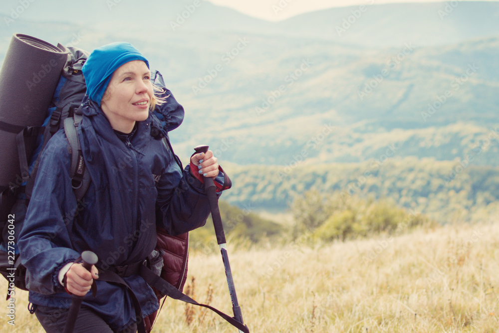 Woman with a large backpack with walking sticks in a hike in the mountains. Woman with a large backpack with walking sticks in a hike in the mountains.