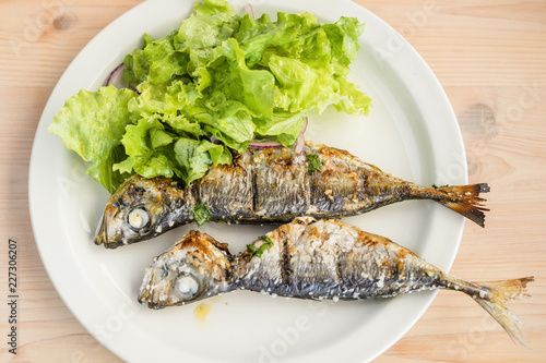 Two freshly barbecued mackerels served with lettuce salad photo