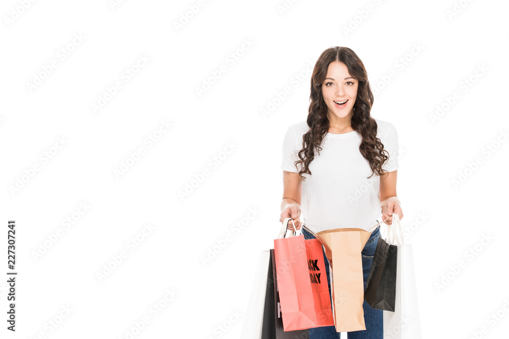 surprised girl holding shopping bags with black friday sale signs isolated on white surprised girl holding shopping bags with black friday sale signs isolated on white