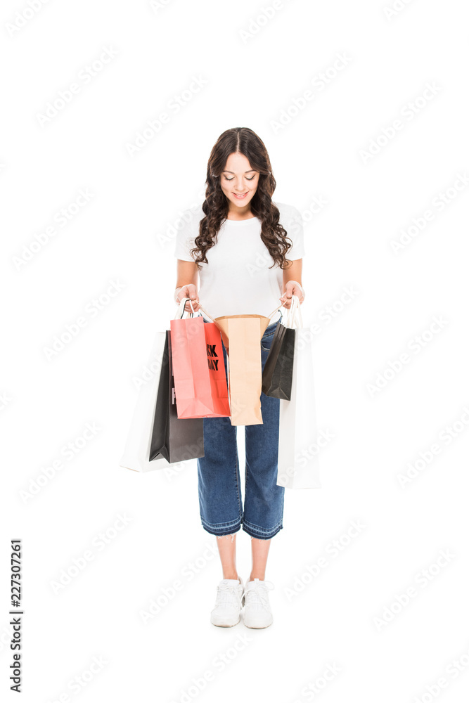 surprised shopper looking into shopping bags with black friday sign isolated on white