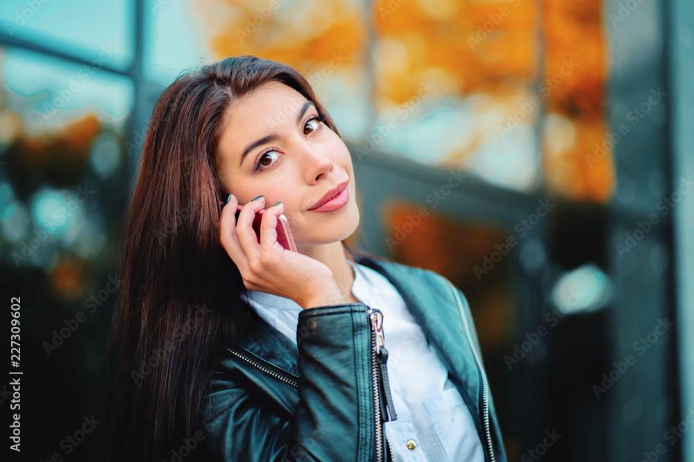 Business woman with smartphone close up near office building. Girl have conversation with cell phone. Beautiful caucasian young woman talking with mobile device. Business woman with smartphone close up near office building. Girl have conversation with cell phone. Beautiful caucasian young woman talking with mobile device.