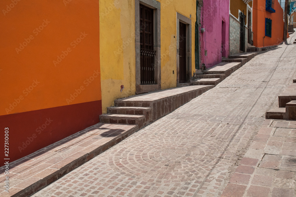 Colorful walls along a cobblestone street in Guanajuato, Mexico, state of Guanajuato