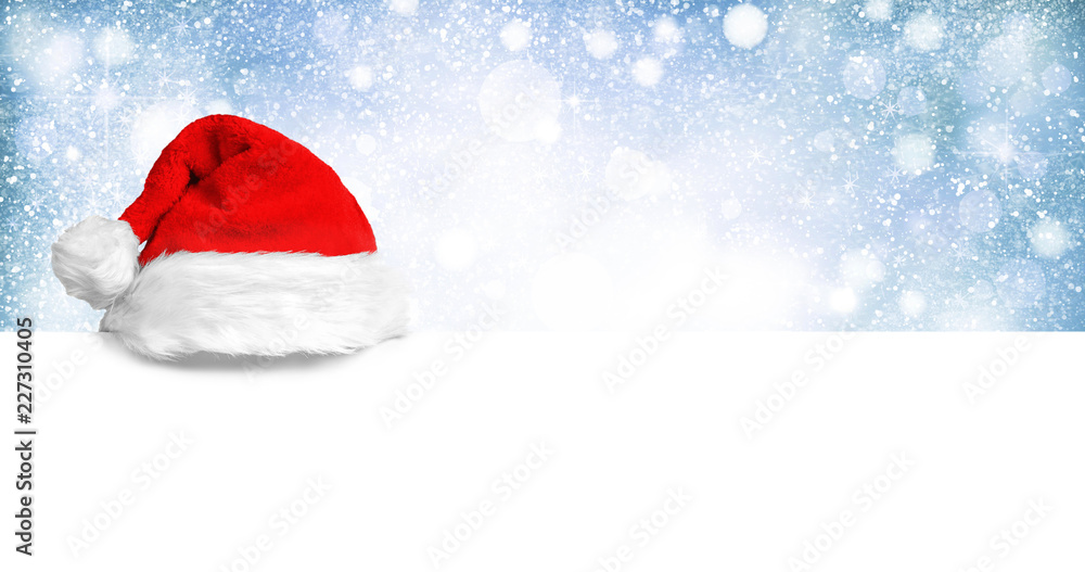 Weihnachtsmannmütze auf weißer Holzplatte Weihnachtsmannmütze auf weißer Holzplatte
