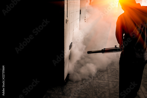 A man use fumigation mosquitoes machine for kill mosquito carrier of Zika virus and dengue fever prevention outbreak in school at the rainy season.Soft and blur focus. photo