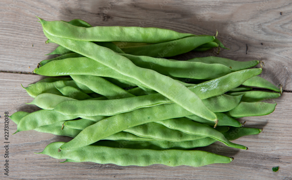 Fresh flat green beans on wooden table Fresh flat green beans on wooden table