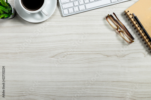 Stylish office table desk. Workspace with laptop, vintage books and coffee mug on white wooden background. Flat lay, top view