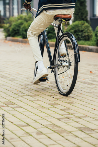 low section view of stylish man riding bicycle in city