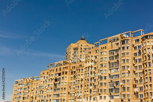 Facade of multistory apartment house on the background of blue sky