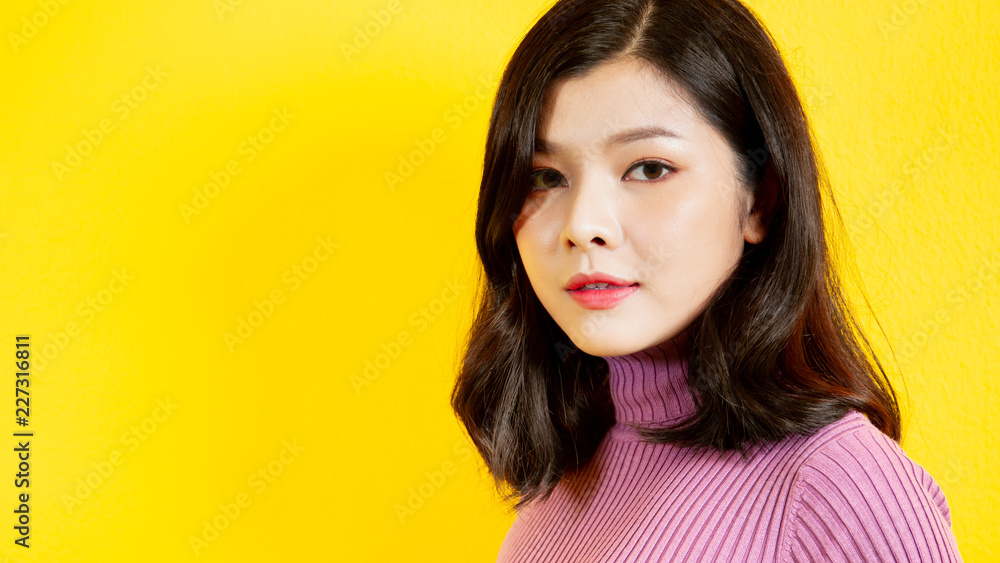 Beautiful Asian women's portrait close up on upper half body on yellow background with a copy space for text and other use. Beautiful Asian women's portrait close up on upper half body on yellow background with a copy space for text and other use.