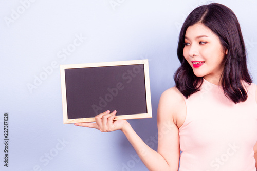 Beautiful Asian girl showing an empty black board close up.