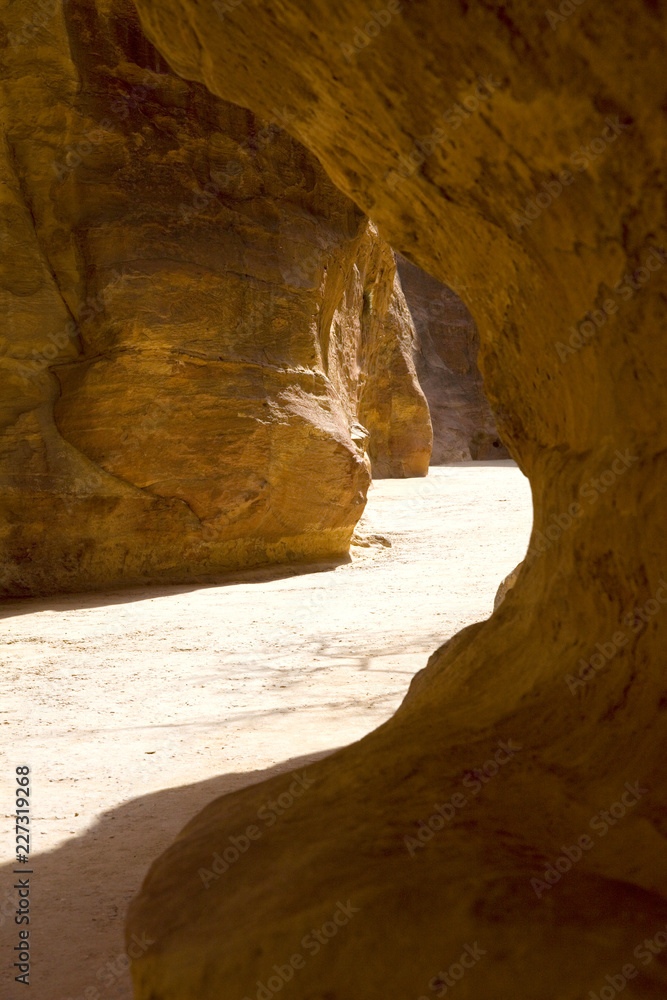Light highlights the path through the Siq to the ancient city, Petra, Jordan.