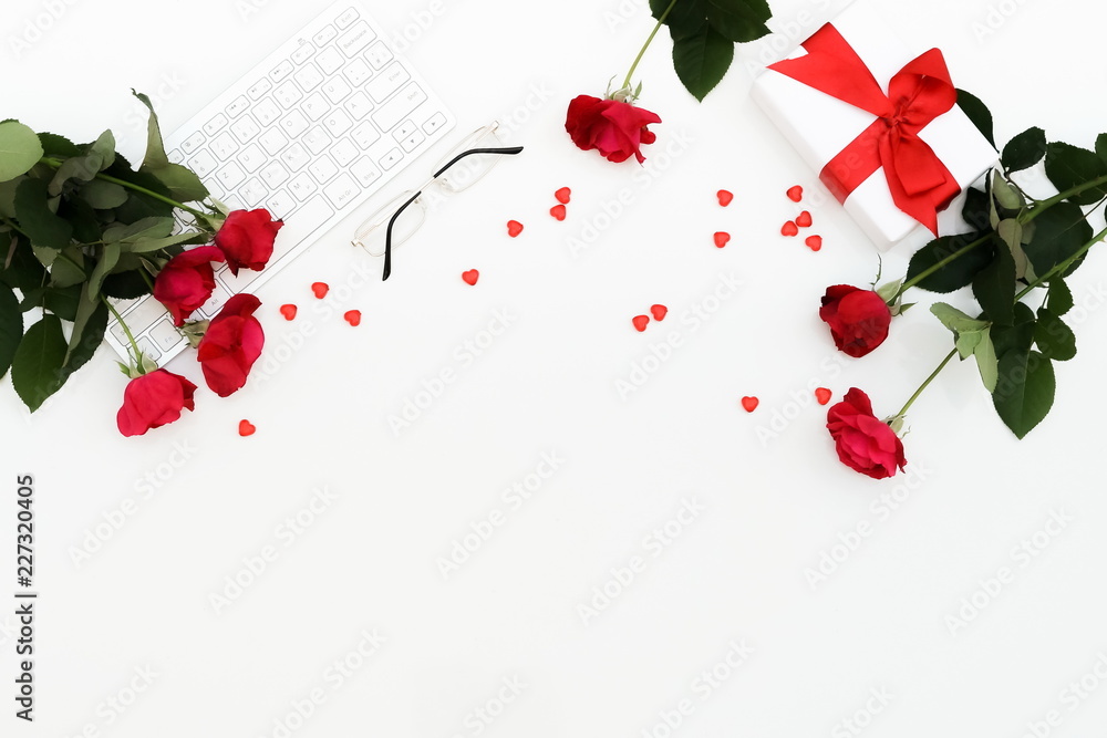 Flat lay, top view Valentine's day women's office desk. Female workspace with laptop, flowers red roses, accessories, glasses, gift on white background. Top view feminine background.Copy space Flat lay, top view Valentine's day women's office desk. Female workspace with laptop, flowers red roses, accessories, glasses, gift on white background. Top view feminine background.Copy space