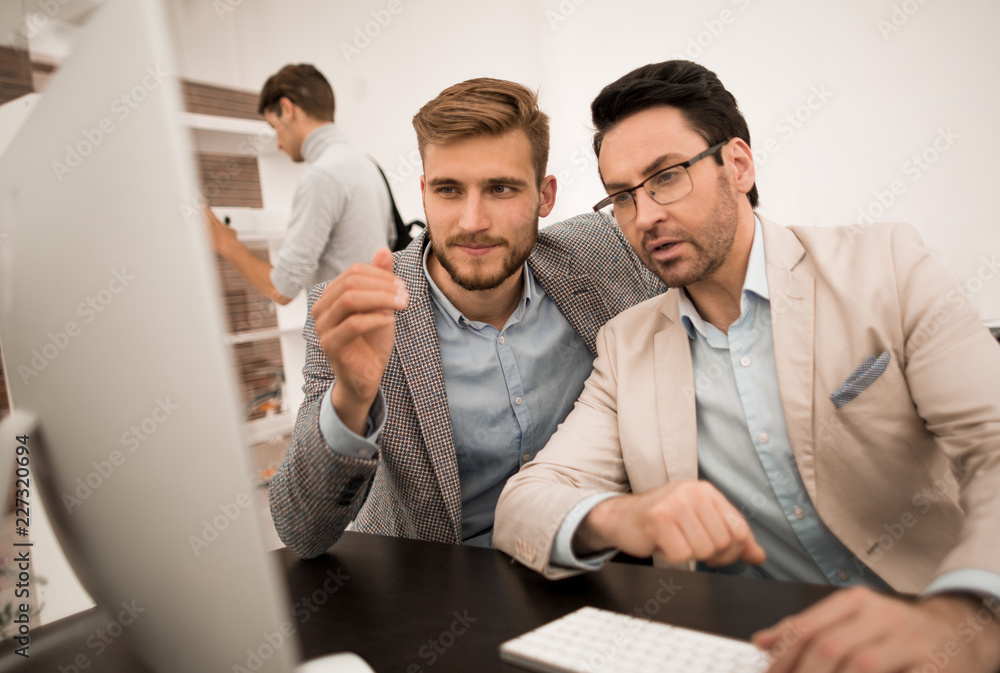 Fototapeta premium two businessmen look at the computer monitor
