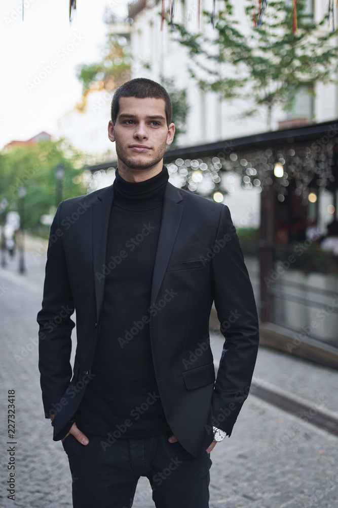 Confident young man walking on a European city street Confident young man walking on a European city street