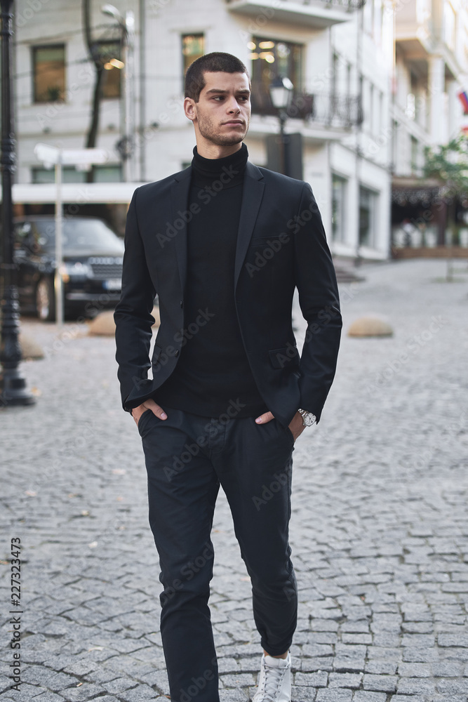 Confident young man walking on a European city street