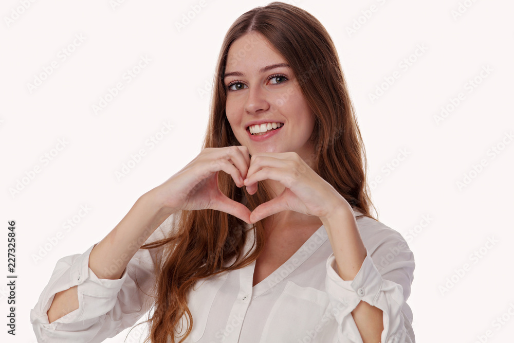 Happy smiling teenage girl making heart shape isolated on white background Happy smiling teenage girl making heart shape isolated on white background