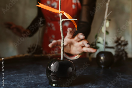 hand taking black halloween apple