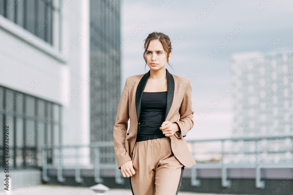 Stylish young business girl. In the city and on the roof. Views and business style. In a hurry and sitting waiting for a meeting.