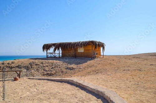 Hut in front of the ocean and blue sky, hut in sand