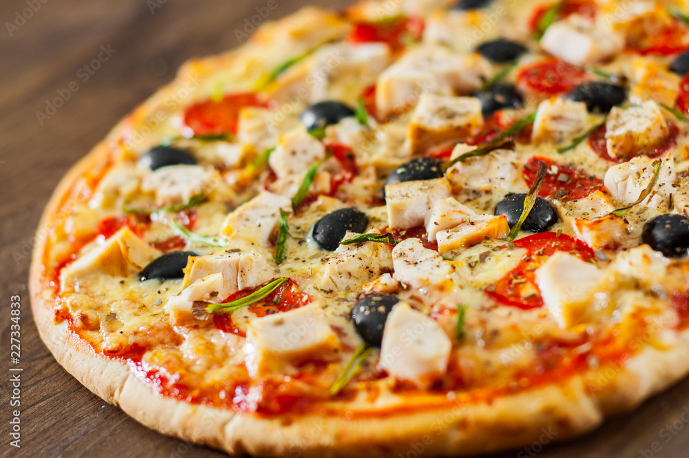 Pizza with Chicken meat, Mozzarella cheese, tomato, olive. Italian pizza on wooden background