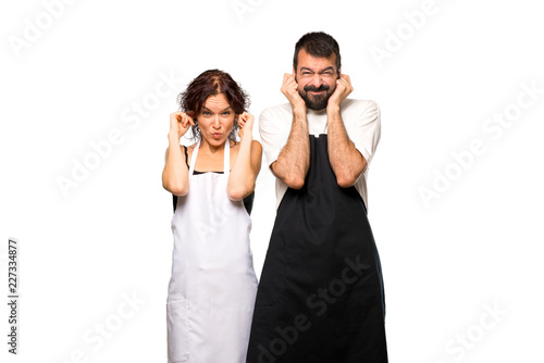Couple of cooks covering ears with hands on isolated white background