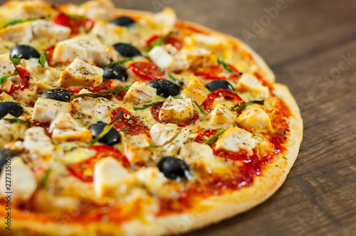 Pizza with Chicken meat, Mozzarella cheese, tomato, olive. Italian pizza on wooden background