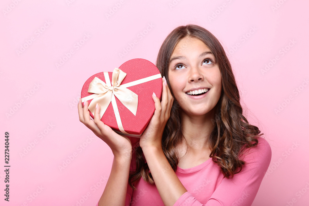 Cute girl holding gift box on pink background Cute girl holding gift box on pink background