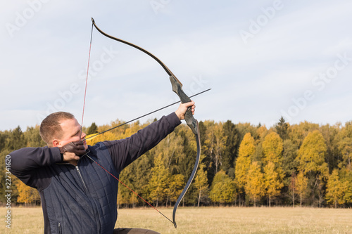 Athlete aiming at a target and shoots an arrow. Archery