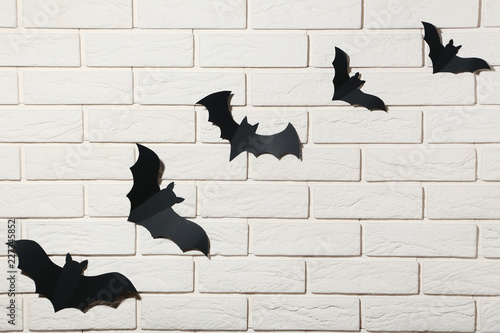 Halloween paper bats on white brick wall background
