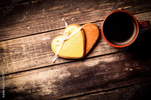 cup of coffee and cookies on the brown wooden background
