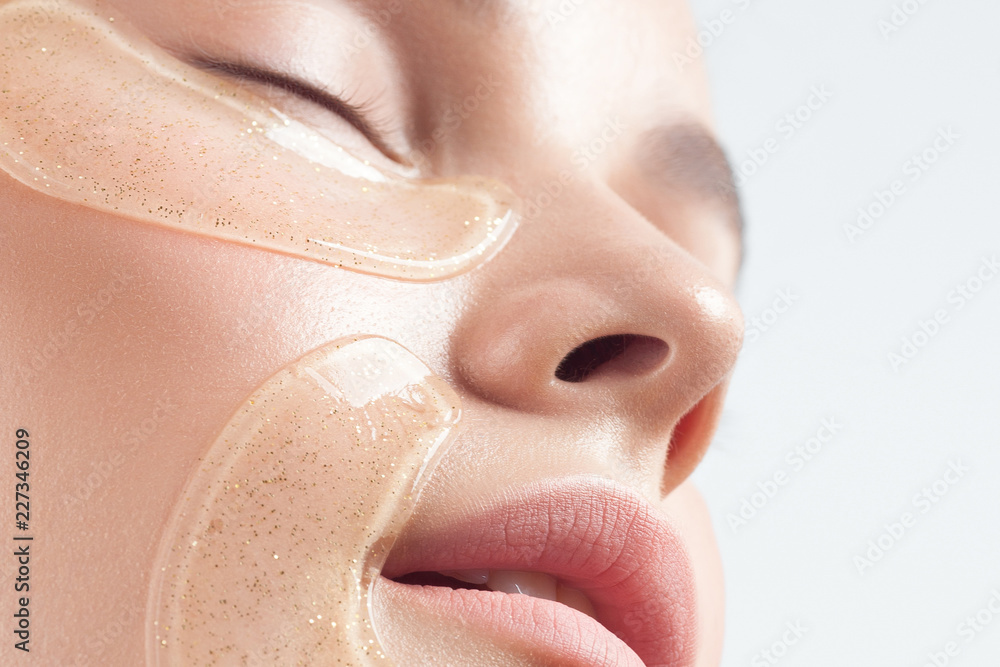 Young beautiful woman with clean perfect skin with cosmetic patches on face close-up Young beautiful woman with clean perfect skin with cosmetic patches on face close-up