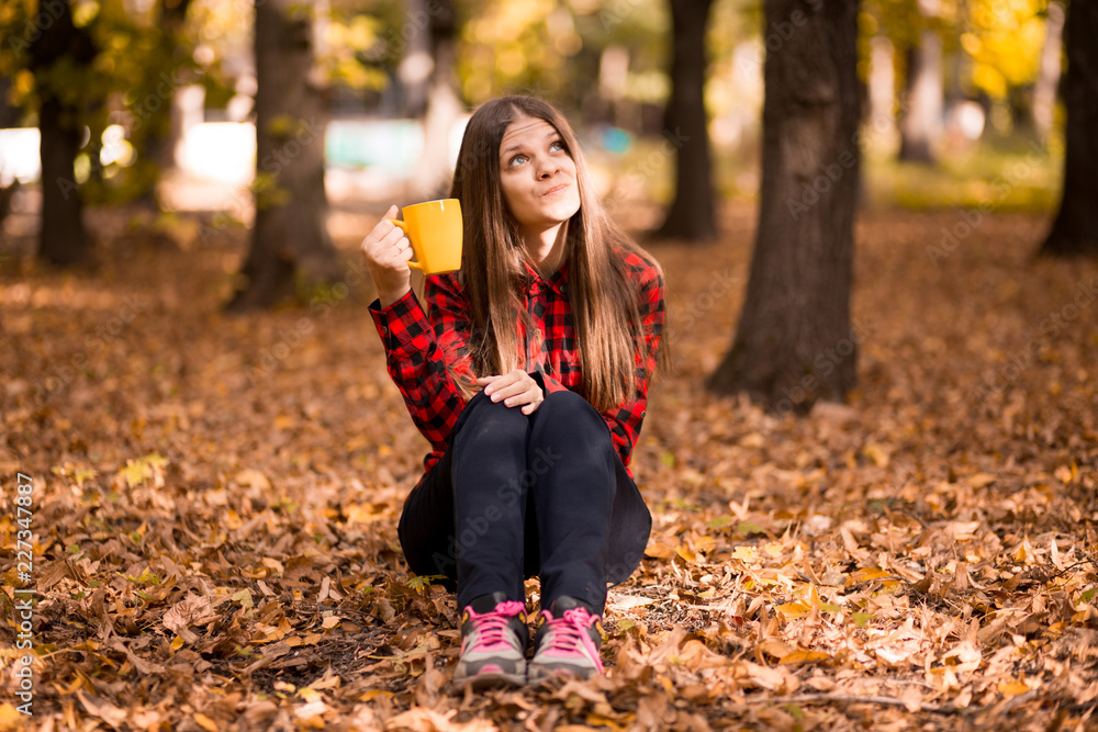 Young woman drink hot tea in autumn park Young woman drink hot tea in autumn park