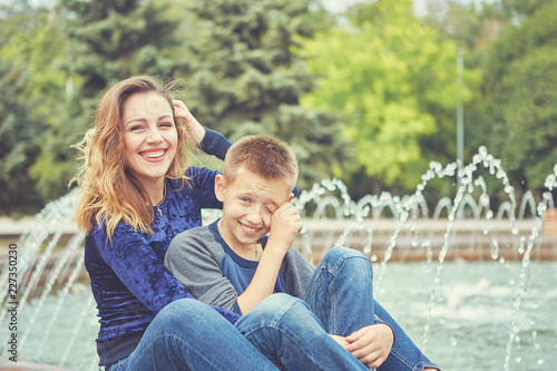 Happy beautiful mother and son enjoying near the fountain © Malsveta