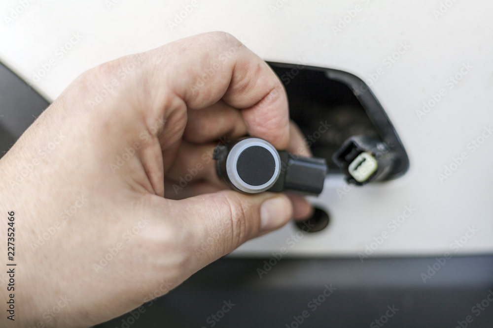 car mechanic changes the parking sensor on the car, the sensor malfunction of parking sensors car mechanic changes the parking sensor on the car, the sensor malfunction of parking sensors
