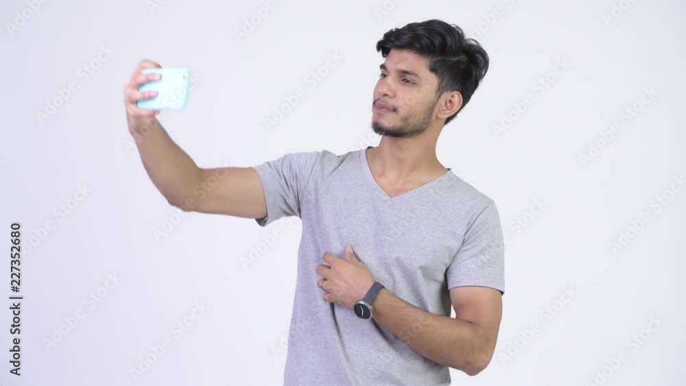 Young happy bearded Indian man taking selfie Young happy bearded Indian man taking selfie