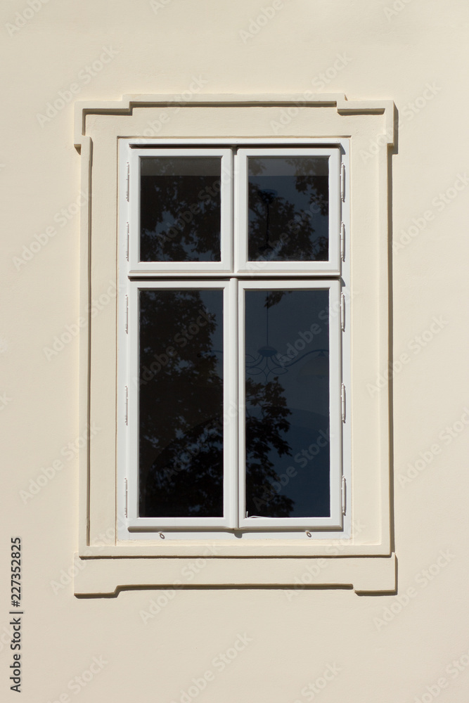 Closed white window on off white building facade Closed white window on off white building facade