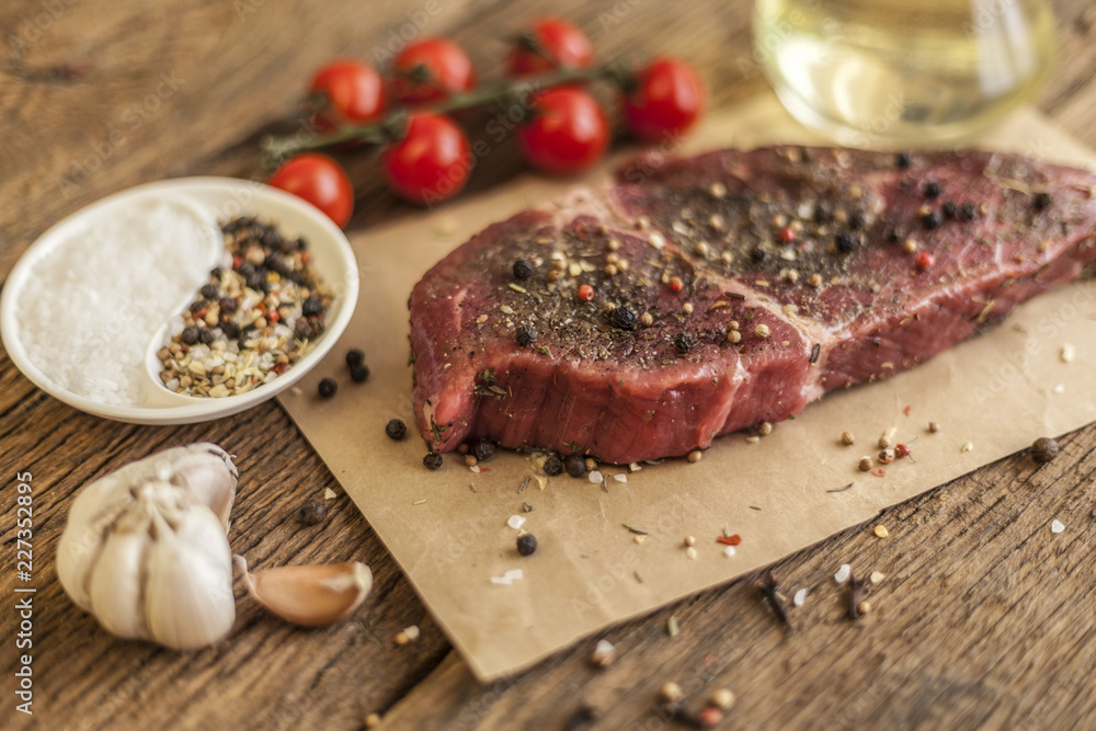 Raw meat steak from beef on dark wooden background,
