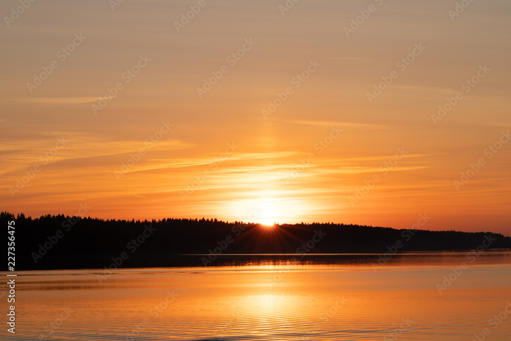 Beautiful Scenic Landscape. Orange Sunset With Ray Of Sun Behind Forest Over River.