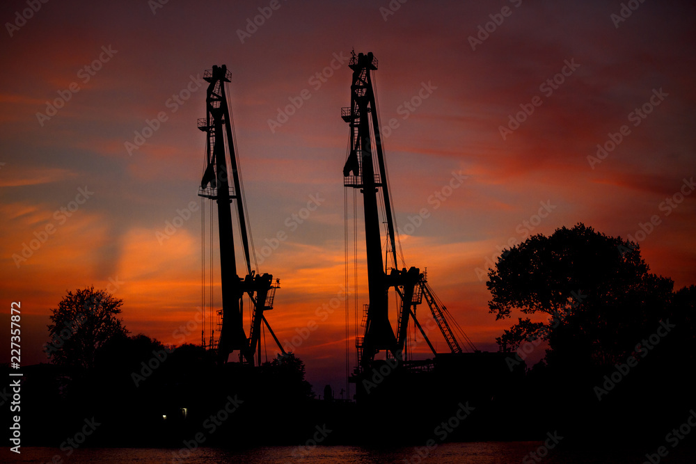 View on seaport with cranes at sunset. Evening panorama of the cargo port View on seaport with cranes at sunset. Evening panorama of the cargo port