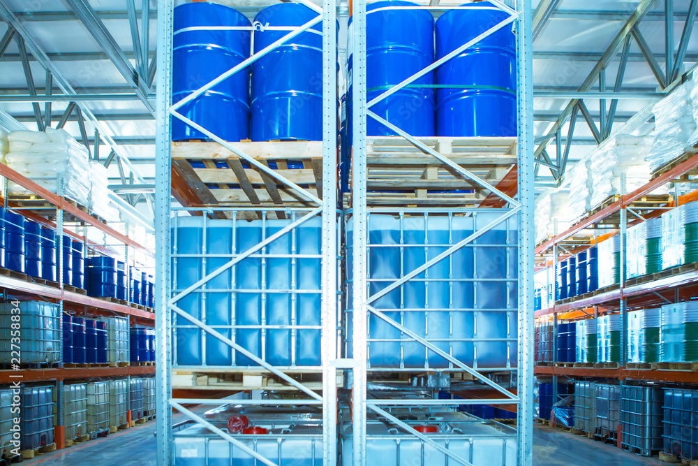 Warehouse of chemical products. Chemical production. Plastic containers and  blue metal barrels in a warehouse. Manufacturing and storage. Stock Photo |  Adobe Stock